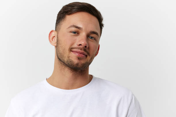 istock Cheerful cute happy young tanned handsome man in basic t-shirt smile at camera posing isolated on over white studio background. Copy space Banner Mockup. People emotions Lifestyle concept. Portrait 2148194710
