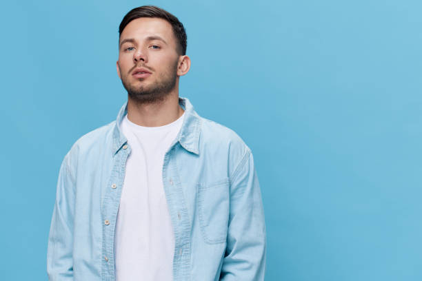 istock Attractive beautiful confident tanned handsome man in casual basic t-shirt posing isolated on blue studio background. Copy space Banner Mockup. People emotions Lifestyle concept. Cool fashion offer 2148194882