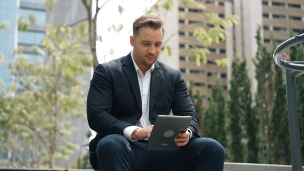 istock Professional business people working tablet while sitting at green city. Urbane. 2148196540