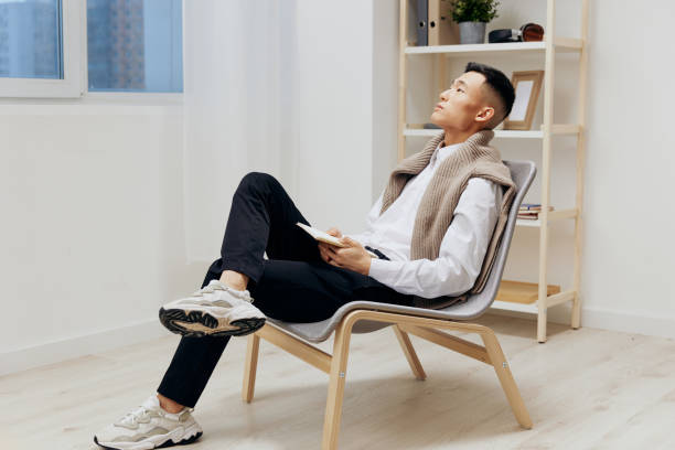 istock Asian man sweater on shoulders tablet internet interior 2148196908