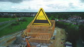 A Sizable Yellow Triangular Sign Placed Atop The Structural Framework ...