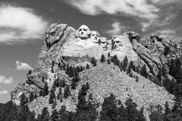 Mount Rushmore National Memorial features carved presidents faces in granite. Iconic sculpture stands above pine forest and talus slope in Black Hills of South Dakota, USA