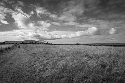 Landscape with footpath across large grass field near Pistone Hill area at Chilterns AONB in monochrome