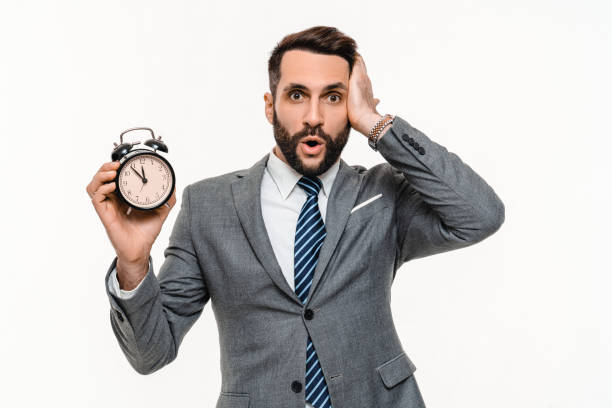istock Surprised Caucasian businessman in formal suit holding clock isolated over white background. 2148199406