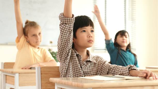 istock Smart boy raising hand for asking and answering teacher at classroom. Pedagogy. 2148201072