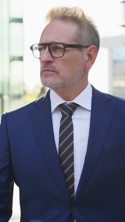 Mature Caucasian manager business man in a white suit and white trousers walks