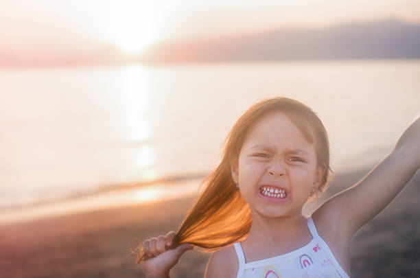 Joyful young woman in a casual outfit expressing positivity and happiness under a serene sunset in an urban setting