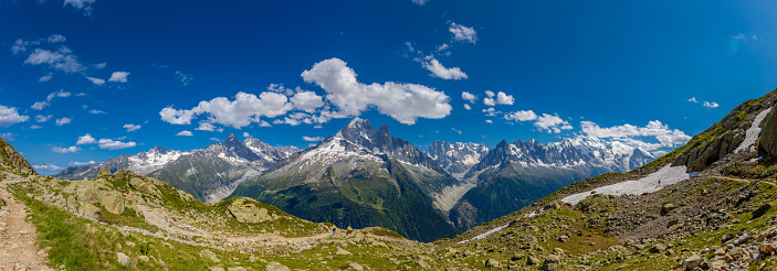 Mountain panorama Tour du Montblanc beautiful mountain peaks and green valley. TMB trekking route scenic landscape in italian, swiss and french Alps in Chamonix valley alpine scene. Panorama of the Alps landscape view