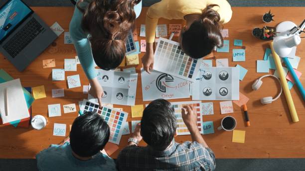istock Top view of skilled designer holding logo while discussing with team. Symposium. 2148203171