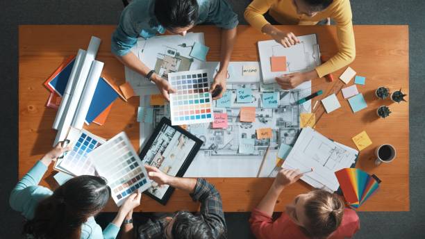 istock Designer team choosing color from palette while looking at blueprint. Symposium. 2148203785