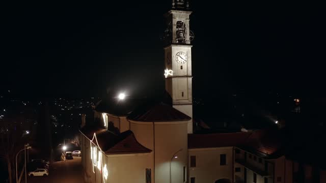 Beautiful night aerial copter 4k footage of illuminated catholic medieval church with belfry tower
