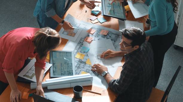 istock Top down of skilled people holding tablet an looking at blueprint. Symposium. 2148209063