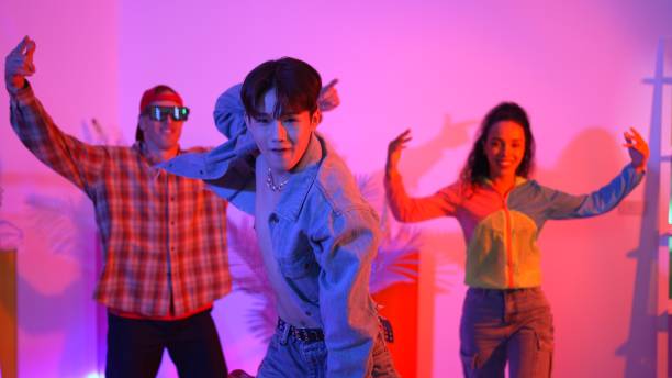 istock Attractive asian dancer dancing and looking at friend cheering him. Regalement. 2148209106
