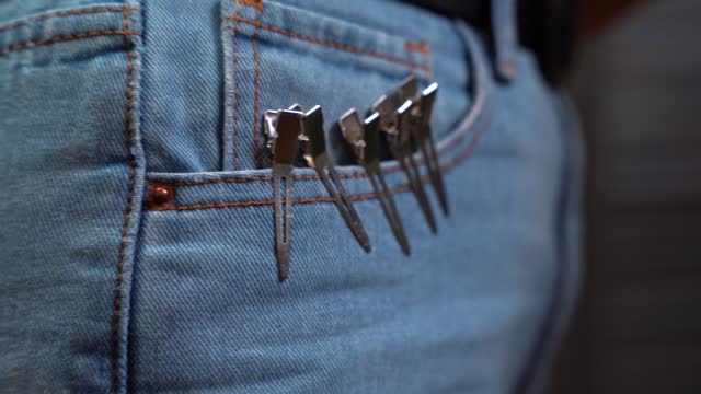 Metal hair clips are attached to pocket of the barber's clothes for easy cutting