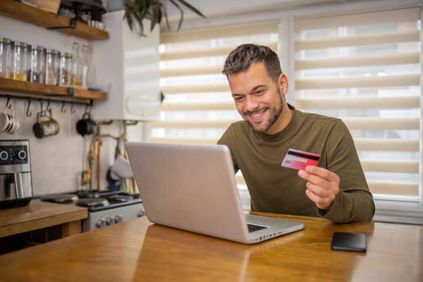 istock Man is shopping online and using a credit card 2148209916