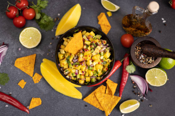 istock Freshly made mango salsa in a black ceramic bowl, nacho chips and ingredients 2148210001