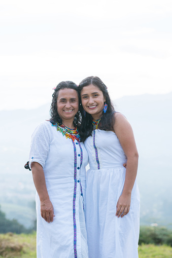 A Colombian women stands serenely, her traditional attire symbolizing wisdom and cultural heritage. With ancestral roots and traditional white attire, they smile, celebrating freedom and connection with the land.
