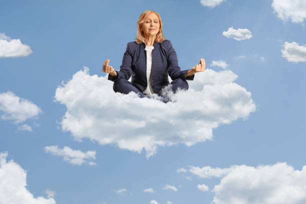 istock Woman sitting and practicing meditation on a cloud 2148214834