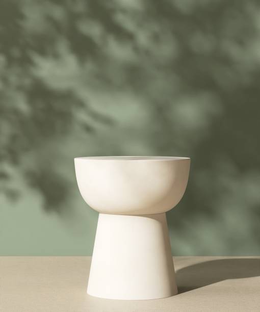 istock Empty white round stone table podium in dappled sunlight, leaf foliage shadow on green concrete wall, brown floor 2148217338