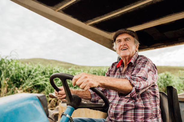 istock Smiling senior farmer driving his tractor 2148218838