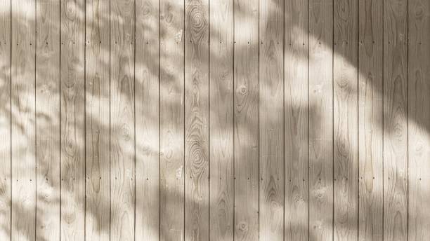 istock Outdoor wood plank fence wall in dappled sunlight, leaf shadow 2148219759