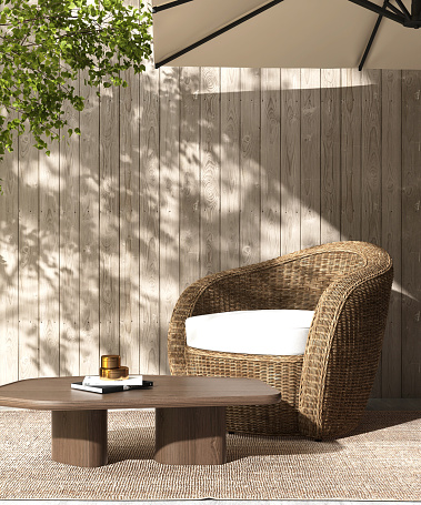 Outdoor rattan couch armchair with cushion, wooden coffee table, rug with umbrella in courtyard in sunlight, tree leaf shadow on wood plank fence wall in background 3D