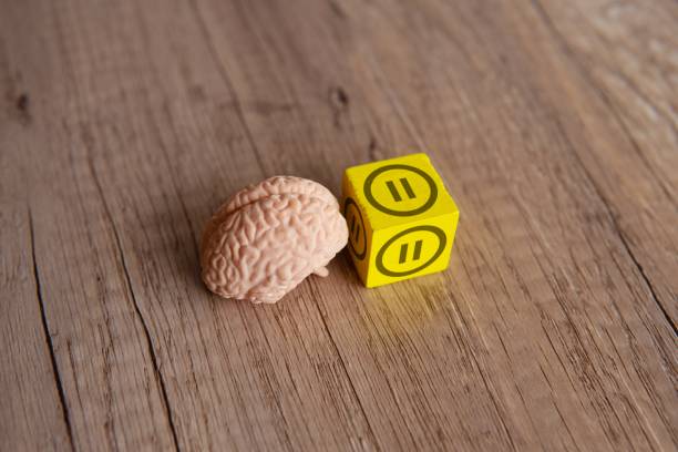 istock Closeup image of brain model and wooden cube with pause button icon. 2148221277