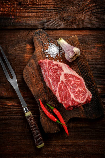 istock Raw Flat Iron beef steak on a wooden Board with seasonings and a meat fork 2148223326