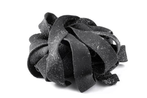 istock Squid ink raw tagliatelle pasta isolated on a white background 2148224471