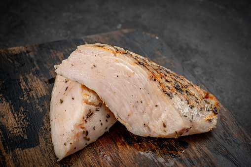 Chicken breast sous vide grilled and cut on a chopping Board