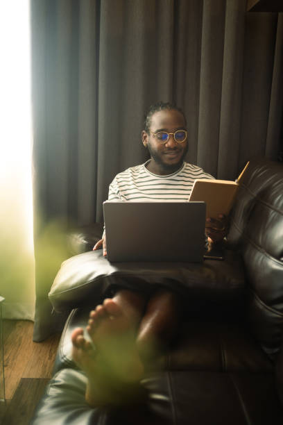 istock Young African American man working or browsing internet on laptop at home 2148224962