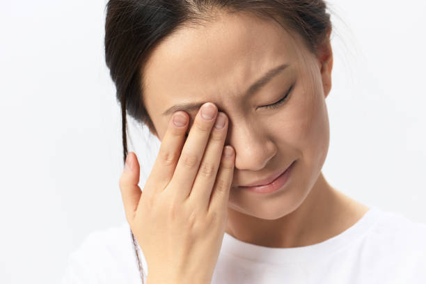 istock Suffering From Strong Pain. Eyesight problem. Tormented suffering tanned beautiful young Asian woman touching eyes posing isolated on white background. Injuries Poor health Illness concept. Cool offer 2148226160