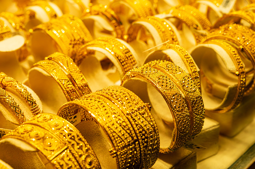 Luxurious gold bracelets on the background. Group of beautiful and elegant gold jewelry - bracelet, expensive accessory