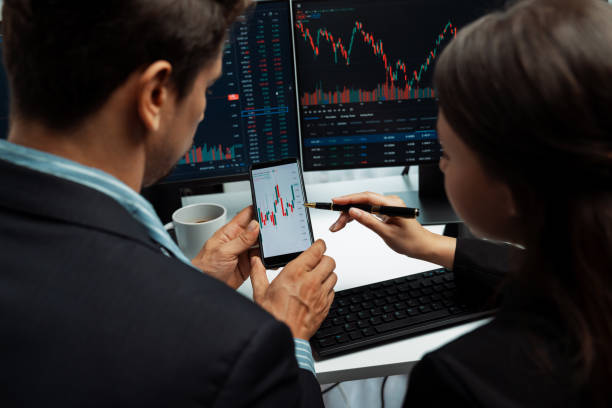 istock Focusing phone with discussing stock market in two business traders. Postulate. 2148227298