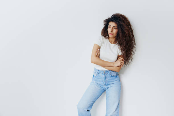 istock Curly serious smart confident happy caucasian woman 20s wearing white basic shirt hold hand crossed folded look aside isolated on plain white background studio portrait. People lifestyle concept 2148229641