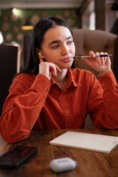 istock Cute thoughtful female writer noting best ideas for magazine article, planning strategy in personal diary, working in cafe. 2148229853