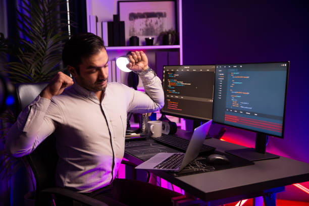istock IT being tried of overwork on solve problem at neon light office. Surmise. 2148231897