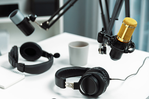 Modern office studio equipment microphone setting, laptop, tablet and headphone prepared with coffee on live streaming with empty host channel steamer podcast social media online concept. Postulate.