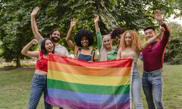 istock Friends Celebrating Pride with Rainbow Flag in Park 2148232160