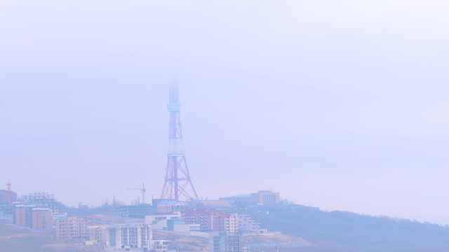 Yerevan TV tower in misty urban scene