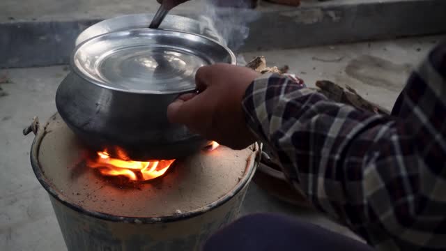 Traditional Outdoor Cooking: Clay Pot with Emerging Red Flames in Uttarakhand, India