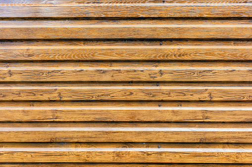 Orange-brown horizontal plastic paneling with wood imitation texture background