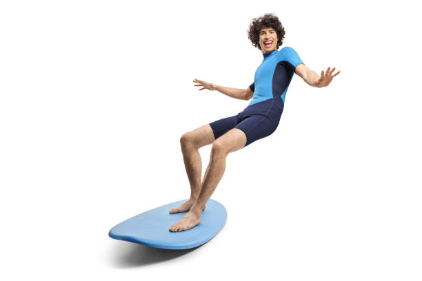 istock Young man in a wetsuit riding a surfboard 2148234515