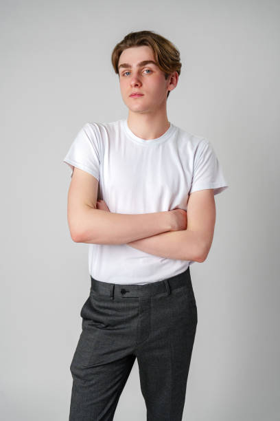 Young Man With Arms Crossed Standing Against a Plain Background in a Studio