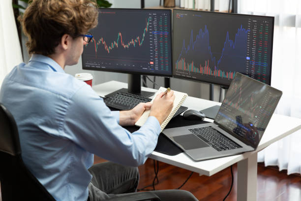 istock Working trader looking on laptop on screens, holding notepad and pen. Gusher. 2148234561