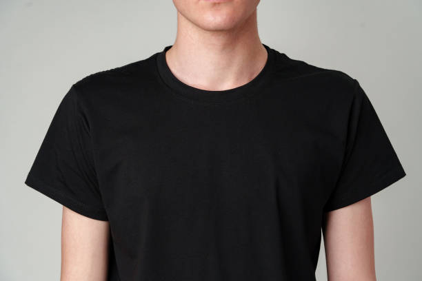 istock Young Man Wearing a Plain Black T-Shirt Against a Gray Background 2148234682