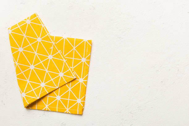 istock top view with yellow empty kitchen napkin isolated on table background. Folded cloth for mockup with copy space, Flat lay. Minimal style 2148236666
