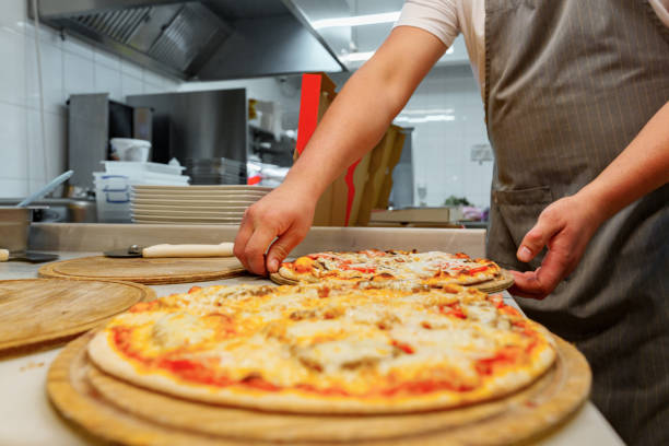 istock Chef Cutting Freshly Baked Pizza in a Commercial Kitchen Setting 2148236795