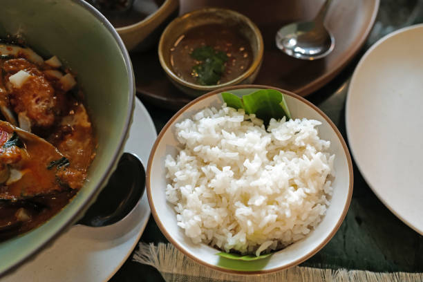 istock Close up steamed white rice served with deep fried fish and Mussels in curry soup 2148237190