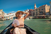 Woman on a gondola tour sailing in Grand Canal in Venice, Italy